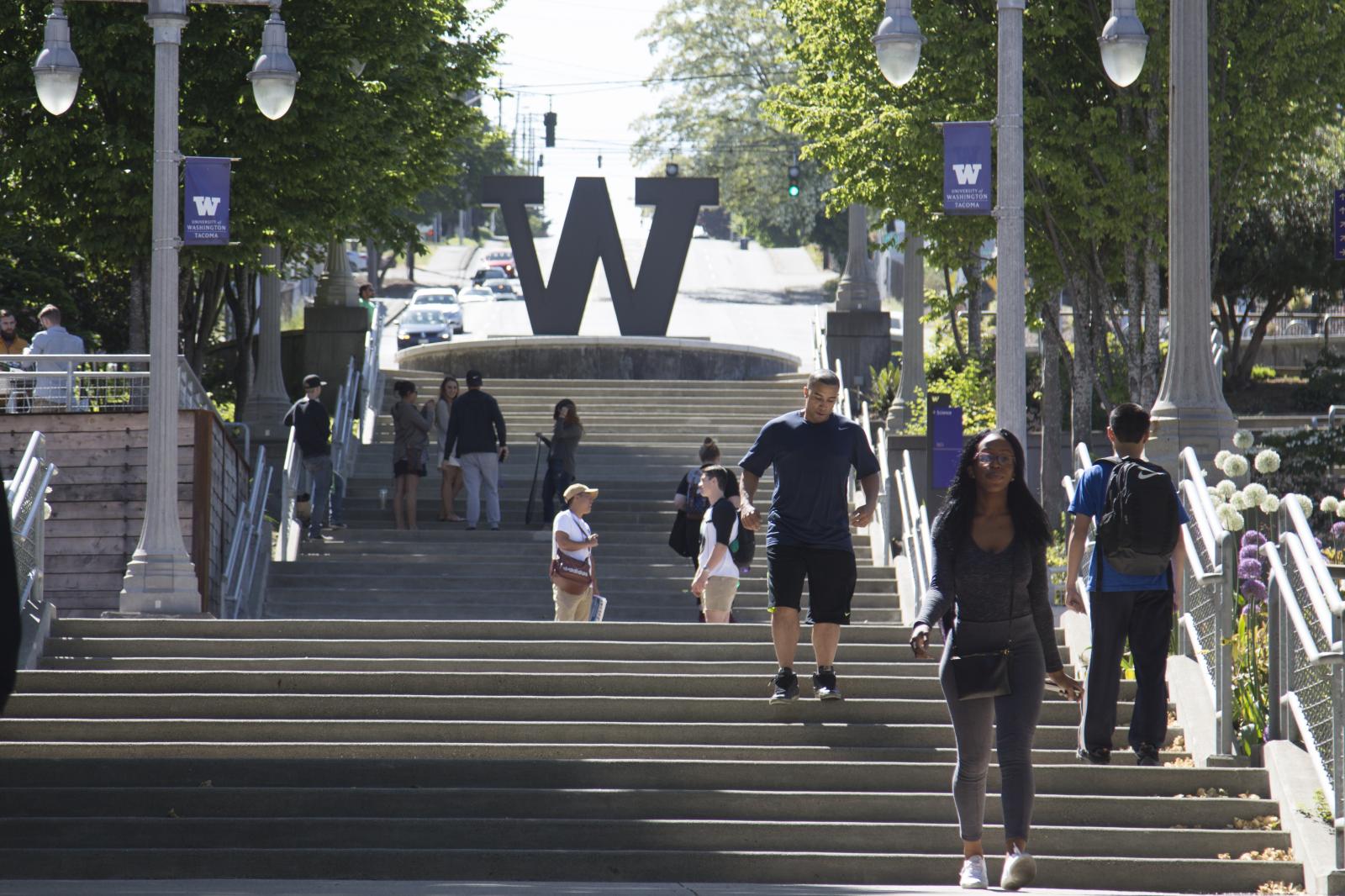 The UW Tacoma campus stairs, showing "W" sculpture with students walking in front. 